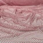 Close-up of pink mesh fabric embedded with tiny pink beads and subtle sparkles.