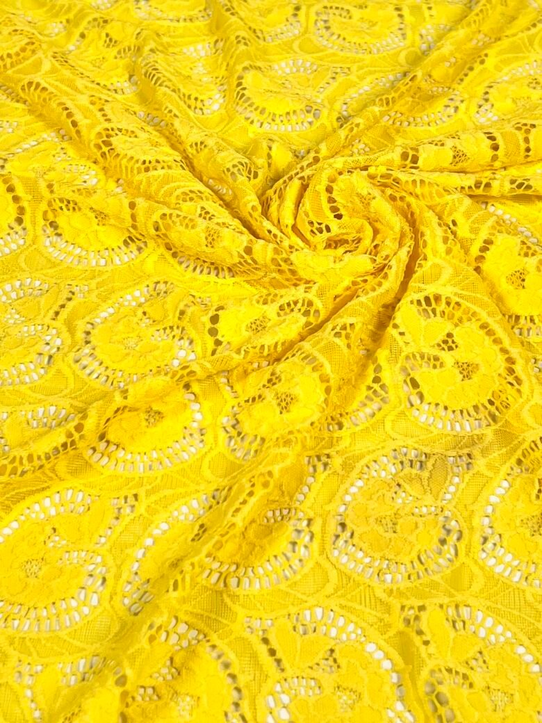 Elastīgs mežģīņu audums ar rakstu dzeltenā krāsā
